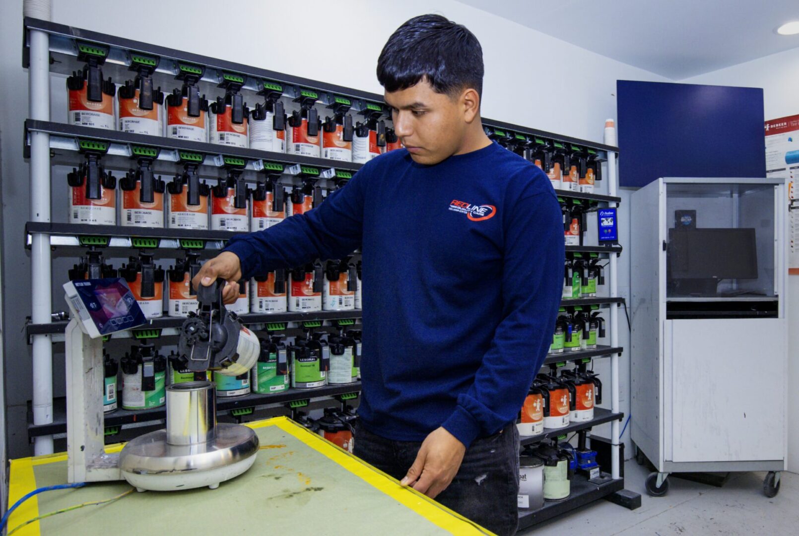 A man working in a store with many bottles of alcohol.